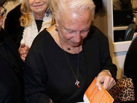 Annamaria Ghedina firma autografi del suo libro vicino al fantagioiello. Foto di Giuseppe Moggia.